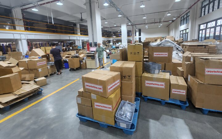 CarPartsChina packing area in Guangzhou with branded cartons on pallets ready to ship
